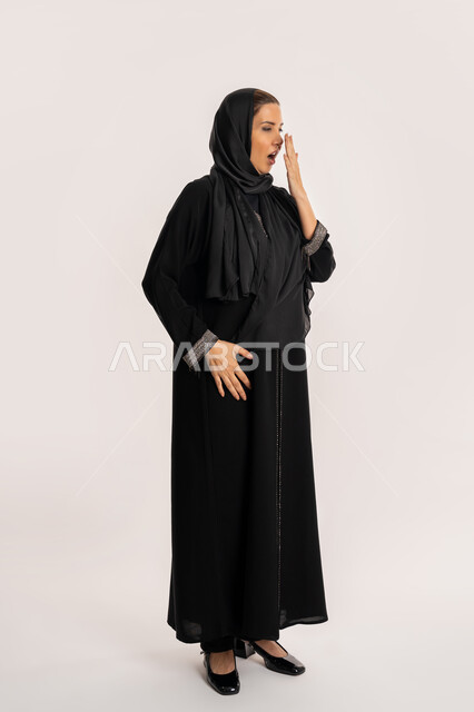 Need for sleep and rest, Saudi woman yawning, gestures of drowsiness and fatigue, portrait of elderly Arab Gulf Emirati woman wearing a black abaya wearing a lazy and lethargic expression, staying up late, full body image, white background