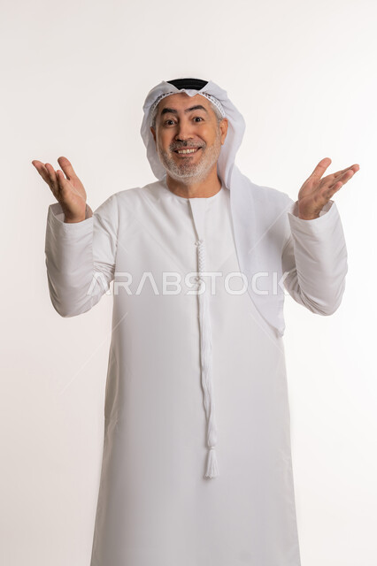 حركات تدل على الاستقبال و الترحيب، ايماءات السعادة والفرح عند رؤية شخص ما, الاشارة الى شيء ما, بورتريه لرجل مسن عربي اماراتي خليجي يرتدي الكندورة و الغترة يرفع ذراعيه للاعلى بتعابير الفرح, خلفية بيضاء