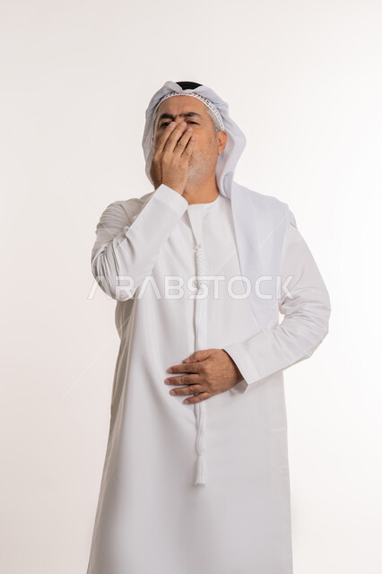 الشعور بالمرض و الزكام والحاجة الى العلاج والدواء, التهاب الأنف التحسسية, بورتريه من الجانب لرجل كبير بالسن عربي اماراتي خليجي يرتدي الغترة والكندورة يضع يديه على وجهه بإيماءات العطاس, خلفية بيضاء