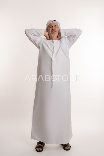 التهاب العضلات والمفاصل، إيماءات الألم في الرقبة، الإحساس بالتعب والإرهاق, بورتريه لرجل مسن عربي اماراتي خليجي يرتدي الكندورة و الغترة يضع يده على رقبته بتعابير الوجع، الحاجه لوضع خطة علاجية, طلب المساعده للذهاب الى المستشفى، صورة الجسم بالكامل، خلفية بيضاء