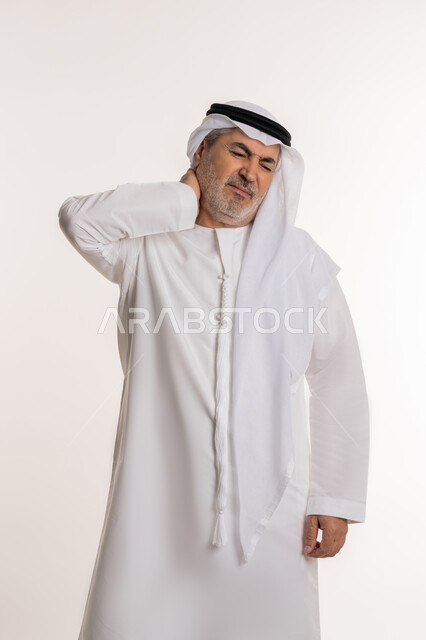 التهاب العضلات والمفاصل، إيماءات الألم في الرقبة، الإحساس بالتعب والإرهاق, بورتريه لرجل مسن عربي اماراتي خليجي يرتدي الكندورة و الغترة يضع يده على رقبته بتعابير الوجع، الحاجه لوضع خطة علاجية, طلب المساعده للذهاب الى المستشفى، خلفية بيضاء