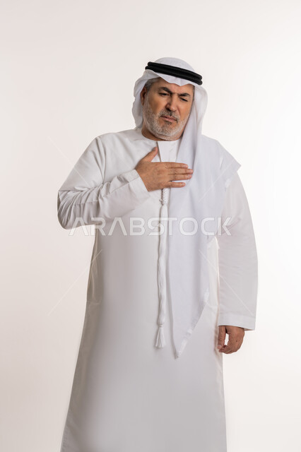 صعوبة التنفس والتعب والألم, الاصابة بنزلة برد والتهاب الحلق، بورتريه لرجل كبير بالسن عربي خليجي إماراتي يرتدي الكندورة والغترة يضع يديه على صدره ويشعر بالاختناق، المرض الشديد والسعال، العدوى بفايروس كورونا، خلفية بيضاء