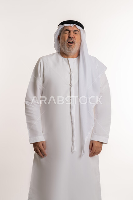 التهاب الأنف التحسسية, الشعور بالمرض و الزكام والحاجة الى العلاج والدواء, بورتريه لرجل كبير بالسن عربي اماراتي خليجي يرتدي الغترة والكندورة يقف بإيماءات العطاس, خلفية بيضاء