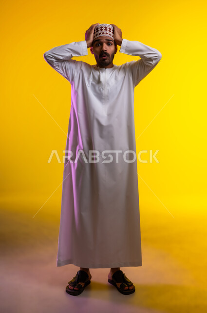 تعابير وجه تدل على حدوث مصيبة ما، بورتريه لرجل عربي خليجي عماني يرتدي الدشداشة والكمه يضع يده على رأسه تظهر عليه علامات الحيرة والوقوع في مشكلة، عدم القدرة على مسك زمام الأمور وفقدان السيطرة، خلفية برتقاليه