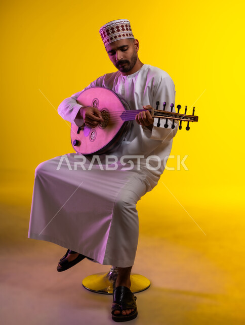 ممارسة هواية العزف على آلالات الموسيقيه، مواهب عربيه وامسيات ثقافيه، بورتريه لرجل عربي خليجي عماني يرتدي الدشداشه والكمه يعزف على آلة العود الوتريه ويقوم بتقديم البرامج الغنائيه، برامج وفنون موسيقية، فن ومسرح ، أنشطه ترفيهيه، خلفيه برتقاليه