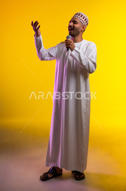 تقديم العروضات المسرحية، الاستمتاع بأداء المواهب الصوتية، بورتريه  لشاب عربي خليجي عماني يرتدي الدشداشه والكمه يمسك بيده المايكروفون، إيماءات وتعابير الاندماج والتفاعل مع الموسيقا، تسجيل مقطع صوتي غنائي، خلفيه برتقاليه