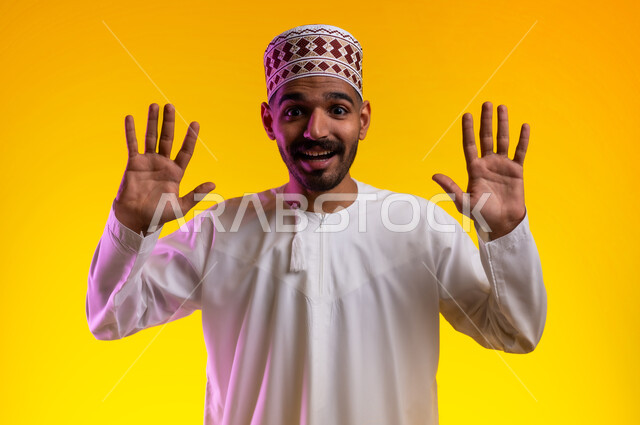 تعابير الرفض والإمتناع، بورتريه لشاب عربي خليجي عماني يرتدي الدشداشة و الكمه يشير بيديه الى الامام  بإيماءات النهي والتوقف عن فعل شئ ما، الشعور بالذهول والصدمه، خلفيه برتقاليه