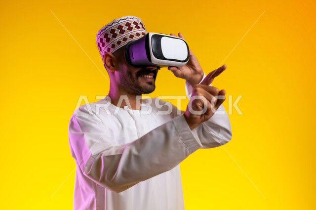 التطور التقني والتكنولوجي, المتعة و التسلية بالمشاهدة عبر نظارة الواقع الافتراضي، بورتريه لشاب عربي خليجي عماني يرتدي الدشداشه والكمه ينظر من خلال نظارات ثلاثية الأبعاد (الفي ار), الاندماج ومحاكاة العالم الخيالي والنظر الى الافلام الواقعيه، خلفيه برتقاليه