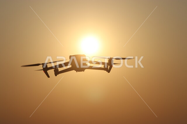 Using modern imaging techniques, silhouette of a drone flying in the sky of Saudi Arabia at sunset, technical and technological development of imaging tools, Saluit
