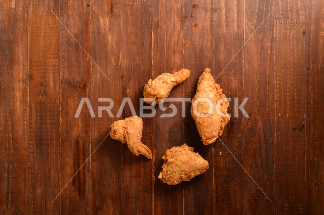 قطع من الدجاج المقلي الكرسبي اللذيذة المغلفة بالبقسماط ، على سطح خشبي