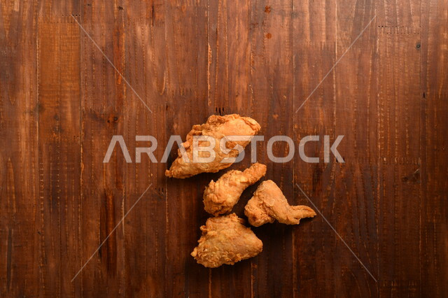 قطع من الدجاج المقلي الكرسبي اللذيذة المغلفة بالبقسماط ، على سطح خشبي