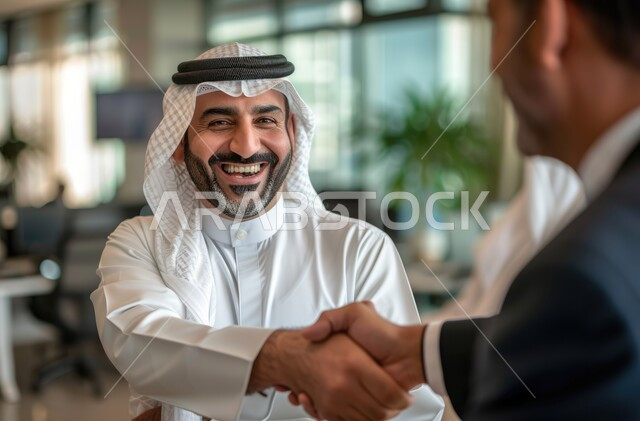 الشراكة في الأعمال والمشاريع الهندسية، صداقات وتعارف وبناء علاقات اجتماعية، عقد صفقات عمل جديدة ناجحة بين رجال الأعمال، صورة مقربة لرجلان عربيان سعوديان خليجيان يقومان بمصافحة بعضهما في مقر الشركة، توسيع مجالات العمل