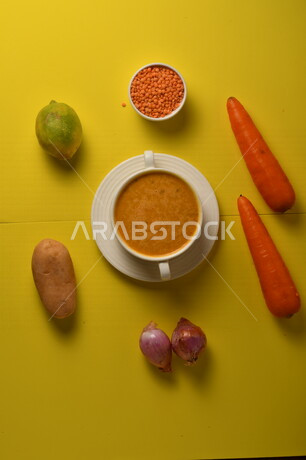 طبق مقبلات ساخنة لذيذ ، شوربة الجزر والعدس الصحية ، الشهية و اللذيذة ، مكونات الشوربة ( الجزر ، العدس )، خلفية صفراء