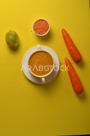 طبق مقبلات ساخنة لذيذ ، شوربة الجزر والعدس الصحية ، الشهية و اللذيذة ، مكونات الشوربة ( الجزر ، العدس )، خلفية صفراء