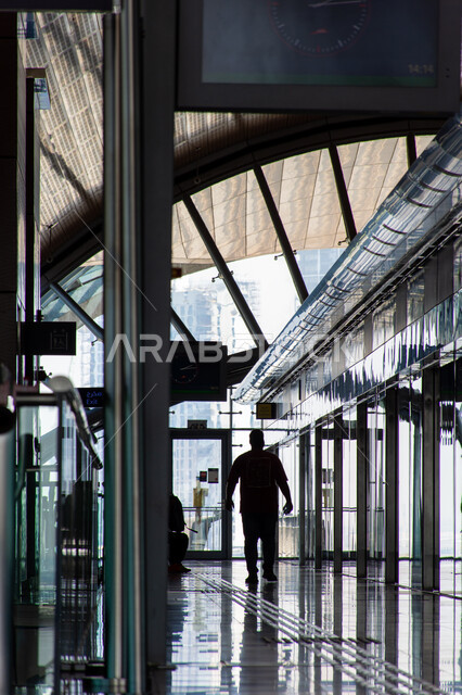 مسافر في محطة الخور الخاصة بمترو دبي، توفير التسهيلات والخدمات للمغادرين والقادمين إلى الإمارات العربية المتحدة، لافتات ولوحات إرشادية، مفهوم المواصلات العامة، محطة وصول المسافرين