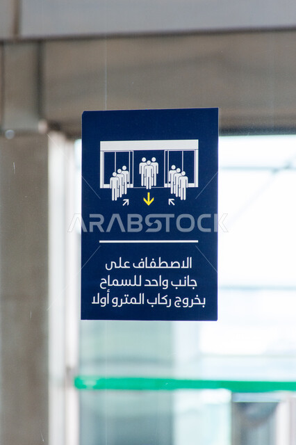Notes and posters on the Dubai Metro gate, a note in Arabic about queuing on one side to allow passengers to exit first, signs and information boards on means of transportation, public transportation in the United Arab Emirates