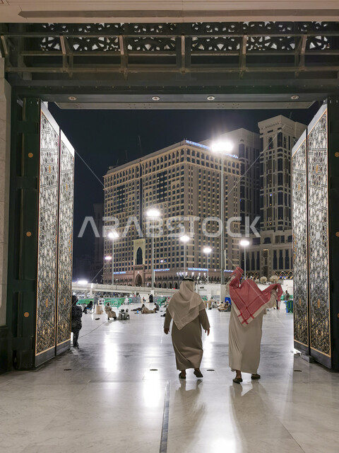 اداء مناسك الحج والعمرة، مجموعة من الحجاج والمعتمرين يقومون بالدخول عبر ابواب المسجد الحرام في مكة المكرمة، العبادة والتقرب إلى الله، معالم دينية اسلامية مقدسة في المملكة العربية السعودية