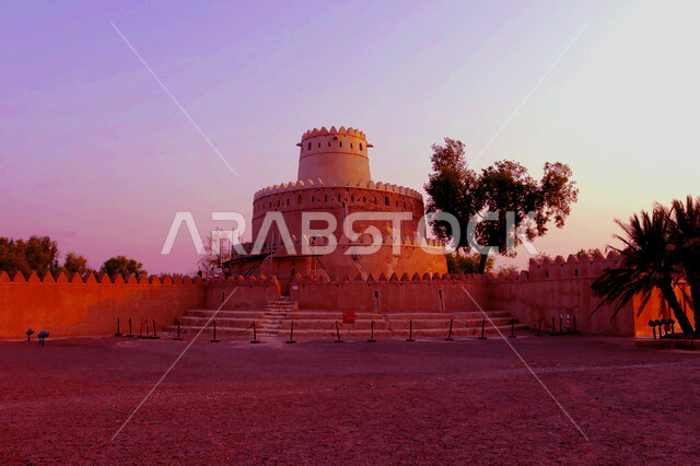 قلعة الجاهلي العريقة في مدينة العين بأبو ظبي وقت الغروب, المباني الطينية المشيدة على الطراز القديم, التصاميم الهندسية الإنشائية للحصون والقلاع الأثرية, معالم وأماكن سياحية مشهورة في الامارات العربية المتحدة
