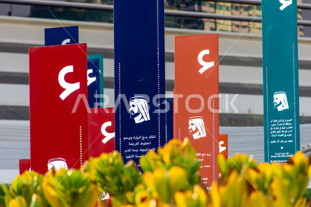 فعاليات ثقافية ترفيهية، التشجيع على القراءة وتنمية المهارات الأدبية والفنية، حب المعرفة والاستكشاف، صورة مقربة لسمو الشيخ محمد بن راشد اّل مكتوم على الأعمدة الملونة في حديقة المكتبة، التصميم الفني المميز، معالم سياحية مشهورة في امارة دبي في الامارات العربية المتحدة