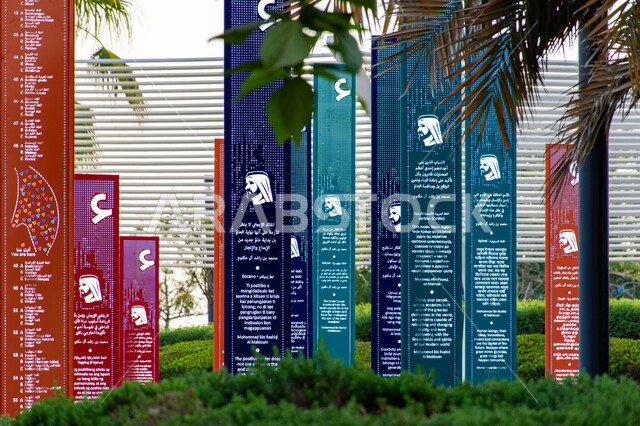 فعاليات ثقافية ترفيهية، التشجيع على القراءة وتنمية المهارات الأدبية والفنية، حب المعرفة والاستكشاف، صورة مقربة لسمو الشيخ محمد بن راشد اّل مكتوم على الأعمدة الملونة في حديقة المكتبة، التصميم الفني المميز، معالم سياحية مشهورة في امارة دبي في الامارات العربية المتحدة