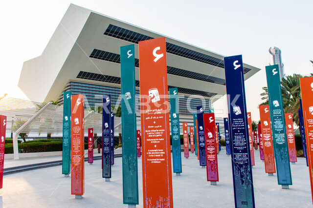Famous tourist attractions in the Emirate of Dubai in the United Arab Emirates, entertaining cultural events, encouraging reading and developing literary and artistic skills, love of knowledge and exploration, a picture of His Highness Sheikh Mohammed bin Rashid Al Maktoum with quotes on the colorful columns in the library garden, distinctive artistic design.