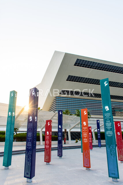 التشجيع على القراءة وتنمية المهارات الأدبية والفنية، حب المعرفة والاستكشاف، صورة  لسمو الشيخ محمد بن راشد اّل مكتوم مع اقتباسات على الأعمدة الملونة في حديقة المكتبة عند غروب الشمس، التصميم الفني المميز، معالم سياحية مشهورة في امارة دبي في الامارات العربية المتحدة