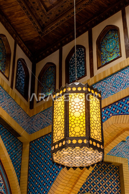 التراث العربي الشرقي الأصيل، مول ابن بطوطة في دبي بالإمارات العربية المتحدة، الأماكن و المعالم السياحية المشهورة، تصاميم وديكورات داخلية، إضاءة وزينة واكسسوارات، صورة مقربة لفانوس رمضاني معلق في السقف، مصباح معدني تقليدي