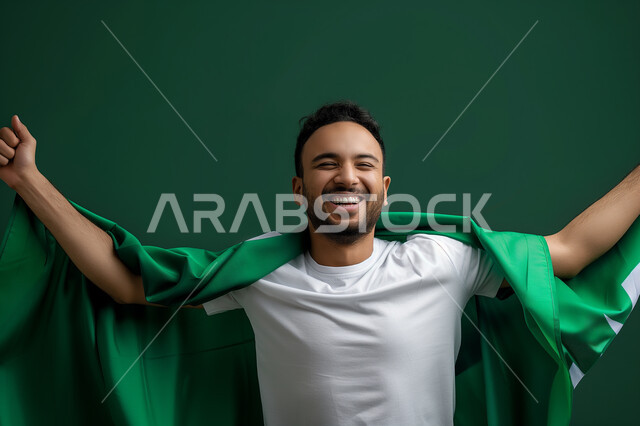 الأعياد والمناسبات الوطنية السعودية, ارتداء العلم السعودي بتقدير واحترام, الافتخار بذكرى اليوم الوطني 23 سبتمبر , التعبير عن الحب والولاء في يوم العلم 11 مارس, بورتريه لرجل عربي سعودي خليجي يشارك في الاحتفالات بإيماءات الحماس والسعادة, خلفية خضراء