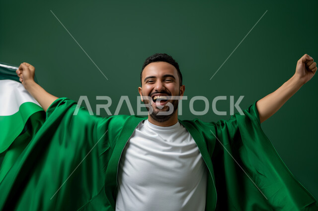 الافتخار بذكرى اليوم الوطني 23 سبتمبر , ارتداء العلم السعودي بتقدير واحترام, التعبير عن الحب والولاء في يوم العلم 11 مارس, بورتريه لرجل عربي سعودي خليجي يشارك في الاحتفالات بإيماءات الحماس والسعادة, الأعياد والمناسبات الوطنية السعودية, خلفية خضراء