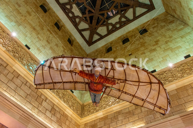 مجسم للعالم الإسلامي عباس بن فرناس معلق بالسقف بساحة الأندلس في مول ابن بطوطة بدبي، أول طيار في التاريخ، التراث العربي الشرقي الأصيل، الأماكن و المعالم السياحية المشهورة في الامارات العربية المتحدة، تصاميم وديكورات داخلية