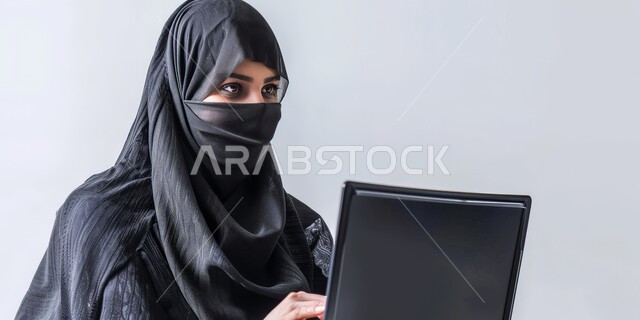 استخدام الأجهزة التكنولوجية الحديثة والمتطورة، مهن ووظائف ادارية مكتبية, إدارة شؤون الأعمال وتنظيمها، بورتريه مقرب لموظفة عربية خليجية سعودية ملثمة تقوم بالعمل على الحاسوب، الشركات والمكاتب في المملكة العربية السعودية، خلفية رمادية