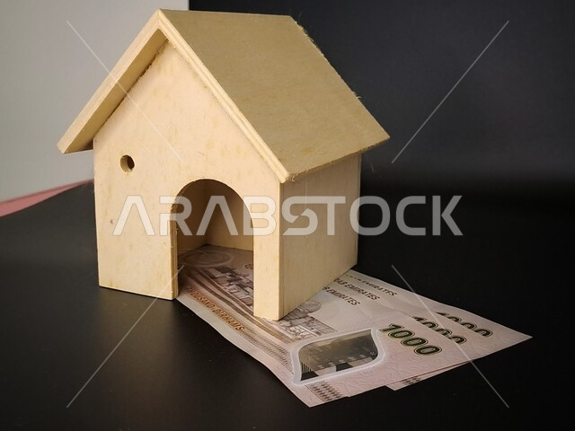 Saving and saving money for housing and ownership, the concept of economic growth, financial profits and sustainability, a close-up image of a house on paper money, investment and interest returns, saving money to buy and own a new home