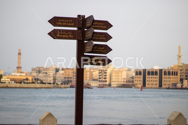 لوحة توجيهية لمساعدة الزوار أمام ميناء خور دبي في النهار، المعالم السياحية الشهيرة، الواجهة المائية والترفيهية في دولة الإمارات, الفن الهندسي المعماري للأبراج وناطحات السحاب المطلة على ساحل الخليج العربي, 