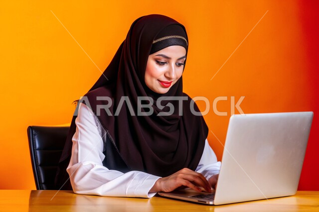 إستخدام الأجهزة التقنية الحديثة، مفهوم التعليم و العمل عن بعد، بورتريه مقرب لشابة عربية خليجية سعودية محجبة مبتسمة تعمل على جهاز الحاسوب المحمول، التسويق الإلكتروني وتصفح الإنترنت، مشاهدة الأفلام عبر اللابتوب، مهن ووظائف نسائية، خلفية ملونة