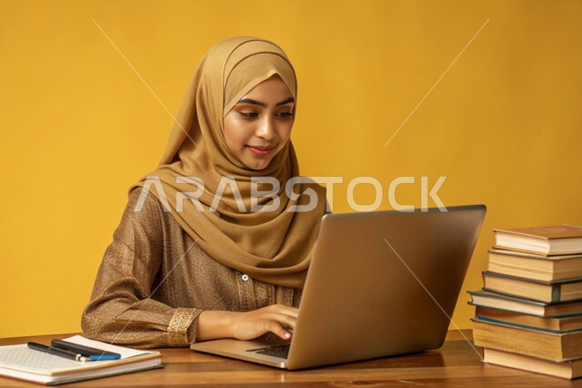 جودة التعليم وتطور الوسائل التعليمية في المملكة العربية السعودية، إستخدام الأجهزة التقنية الحديثة، مفهوم التعليم و العمل عن بعد، بورتريه مقرب لفتاة عربية خليجية سعودية محجبة مبتسمة تعمل على جهاز الحاسوب المحمول، خلفية صفراء