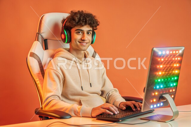The use of modern techniques and technology, a live broadcast platform in the world of video games, a portrait of a Saudi Gulf Arab young man wearing a headset, looking at the camera, working on a laptop, the concept of integration and interaction, a colorful background