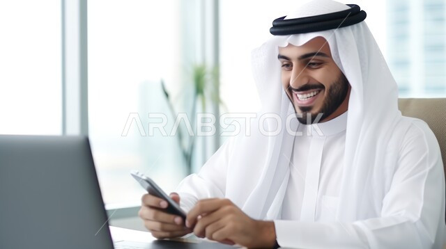 Completing required office tasks, integrating work with technology and technology, a Saudi Gulf Arab man wearing the traditional dress and ghutra sitting in his office and browsing business management applications via his laptop, Saudi professions and jobs in the Kingdom