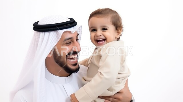 مفهوم الترابط الأسري, الأبوة وحنان الأب, بورتريه مقرب لرجل عربي خليجي سعودي يرتدي الثوب التقليدي ويقوم باحتضان طفله الصغير بحب, قضاء أوقات ممتعة مع الأبناء, تحمل مسؤولية والاعتناء بهم، خلفية بيضاء