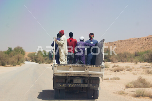وسائل النقل و المواصلات, التنقل في المناطق البرية, صورة من الخلف لمجموعة من الأشخاص العرب يقفون داخل شاحنة, الأماكن الصحراوية في المملكة العربية السعودية