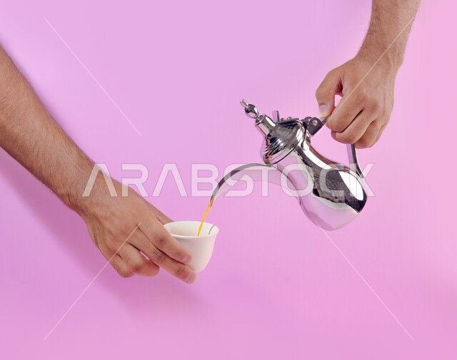 A silver dallah made of fine Arabic coffee, a portrait of a close friend of my lady, a Saudi Gulf Arab man pouring a coffee drink into a cup, the concept of welcoming and honoring a guest, offering a hot coffee drink to visitors, authentic customs inherited among the Arabs, a pink background