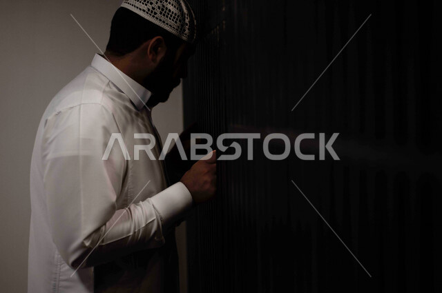 رجل عربي خليجي سعودي داخل السجن ، يمسك القضبان الحديدية ، سجين سعودي ينتظر الحرية ، الشعور بالندم والوحدة 