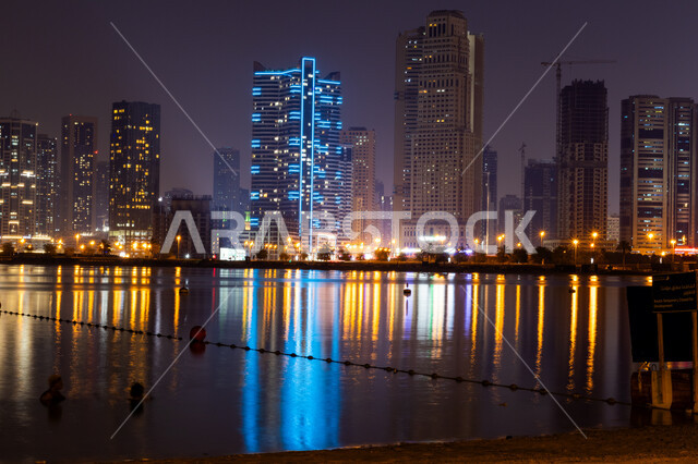 الفن الهندسي المعماري للابراج السكنية في إمارة دبي في وضع النهار، الواجهة البحرية الرومانسية في الإمارات العربية المتحدة، الطبيعة البحرية الساحلية, الاهتمام بزراعة أشجار النخيل, منظر السماء المليئة بالغيوم .