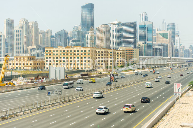 السيارات في الشوارع والطرق بوضح النهار، حركة المرور لطريق الشيخ زايد العام في دبي بالإمارات العربية المتحدة، النقل و المواصلات و السياحة في الإمارات، الابراج و ناطحات السحاب، معالم هندسية مشهورة