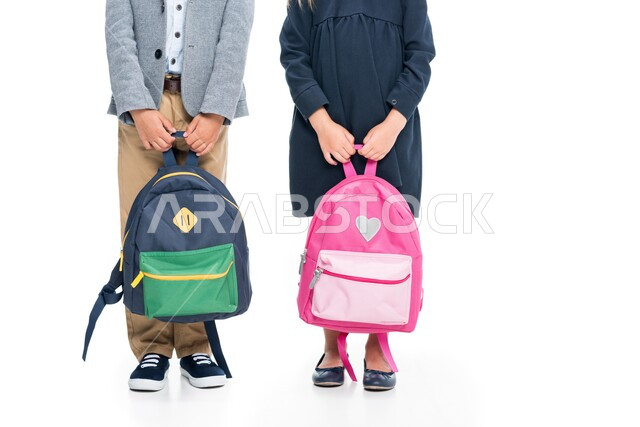 التجهز للذهاب الى المدرسة، التعليم في المملكة العربية السعودية، بورتريه لطالب وطالبة يحملان الحقيبة المدرسية استعدادا للبدء بالعام الدراسي الجديد، العودة الى المدارس التعليمية في المملكة،متابعة الدروس والواجبات، خلفية بيضاء
