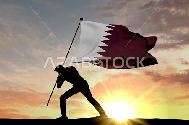 Remembering history and national identity, commemorating the Qatari National Day, December 18, a silhouette of a Qatari Gulf Arab man erecting the flag of the Qatari state in the ground at sunset, pride, pride, love of the homeland and belonging to it, Salulite.