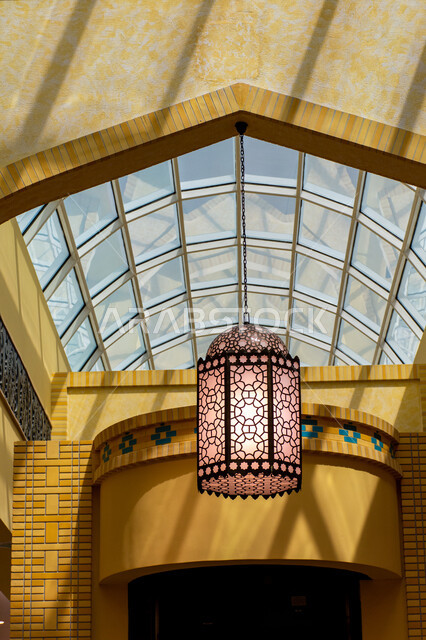 التراث العربي الشرقي الأصيل، مول ابن بطوطة في دبي بالإمارات العربية المتحدة، الأماكن و المعالم السياحية المشهورة، تصاميم وديكورات داخلية، إضاءة وزينة واكسسوارات، صورة مقربة فانوس رمضاني معلق في السقف، مصباح معدني تقليدي