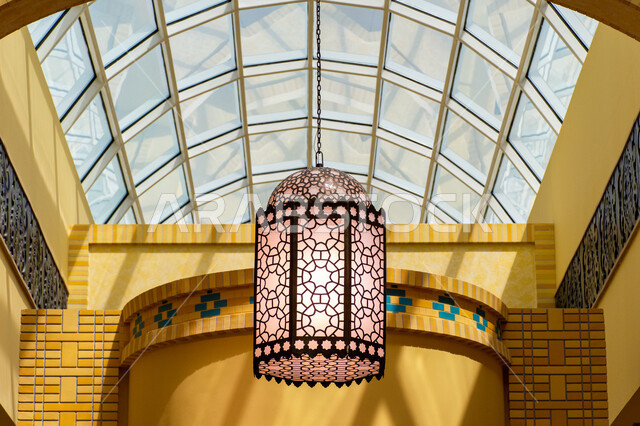 التراث العربي الشرقي الأصيل، مول ابن بطوطة في دبي بالإمارات العربية المتحدة، الأماكن و المعالم السياحية المشهورة، تصاميم وديكورات داخلية، إضاءة وزينة واكسسوارات، صورة مقربة فانوس رمضاني معلق في السقف، مصباح معدني تقليدي