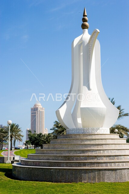 مجسم فني ابيض على شكل ابريق قهوة عربية، نصب تذكاري المعروف باسم "درب الساعي" في منطقة الكورنيش في الدوحة، رمز الكرم والضيافة، الفن الهندسي في طرق وشوارع دولة قطر،اماكن ومعالم سياحية مشهورة