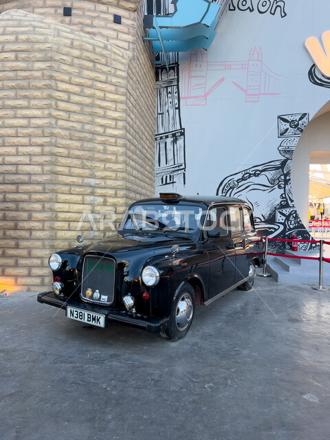 سيارة سوداء كلاسيكية بجانب مبنى الألعاب والترفيه في البوليفارد ورلد في مدينة الرياض، الاستمتاع بالتجارب الممتعة في أبرز المناطق الترفيهية بالمملكة العربية السعودية، اكتشاف الحضارات والثقافات حول العالم, معالم جذب واستقطاب السائحين