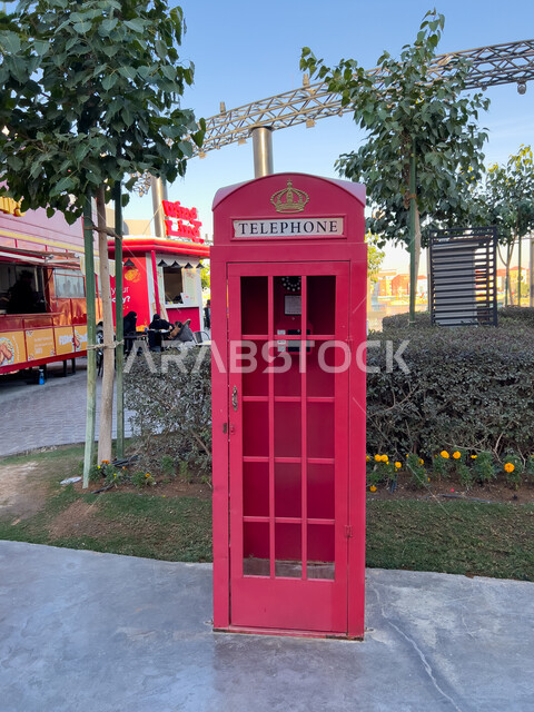 صندوق هاتف باللون الأحمر في البوليفارد ورلد في مدينة الرياض، الاستمتاع بالتجارب الممتعة في أبرز المناطق الترفيهية بالمملكة العربية السعودية، اكتشاف الحضارات والثقافات حول العالم, الاهتمام بالتشجير وزراعة النباتات الخضراء، معالم جذب واستقطاب السائحين